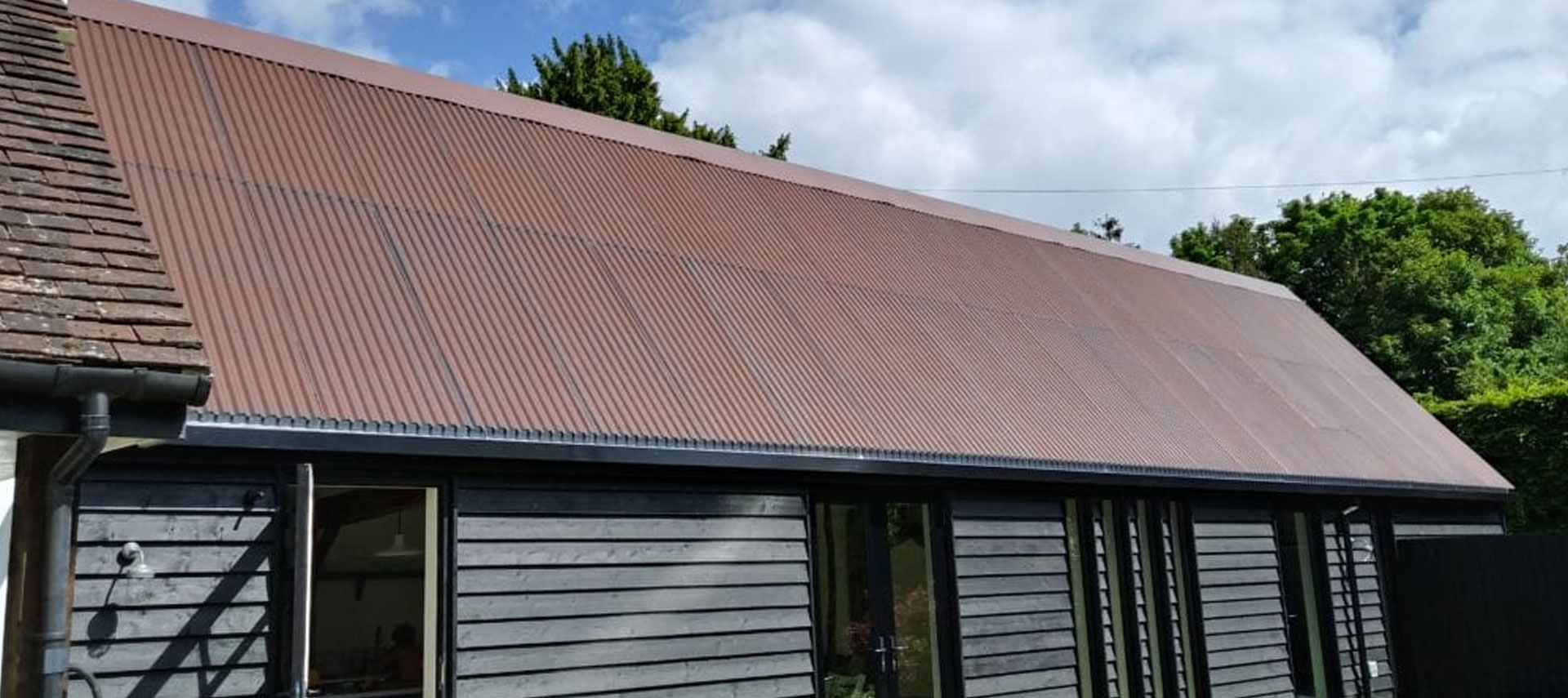 Architectural metal mesh profiled sheet roofing installed on a modern barn building exterior.