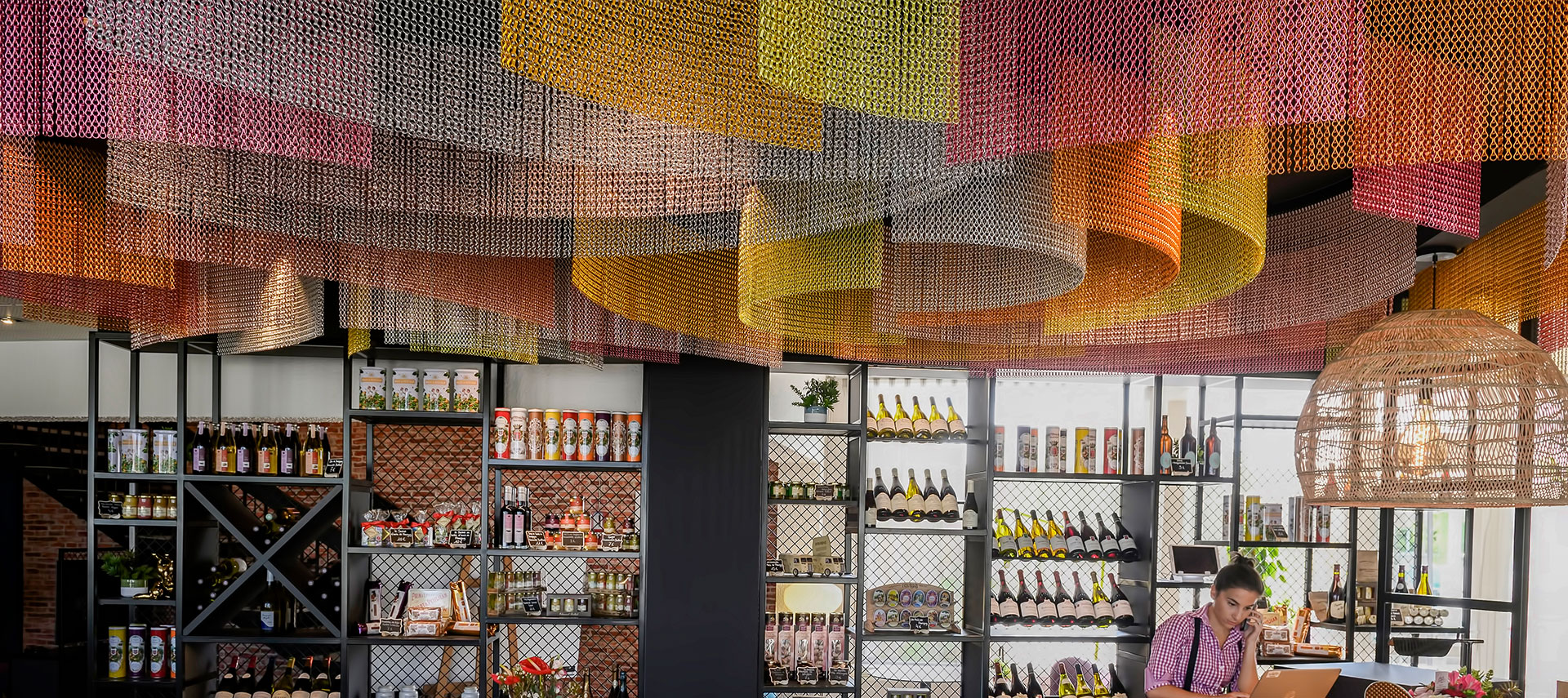 Decorative metal ceiling installation with layered mesh in a hospitality environment