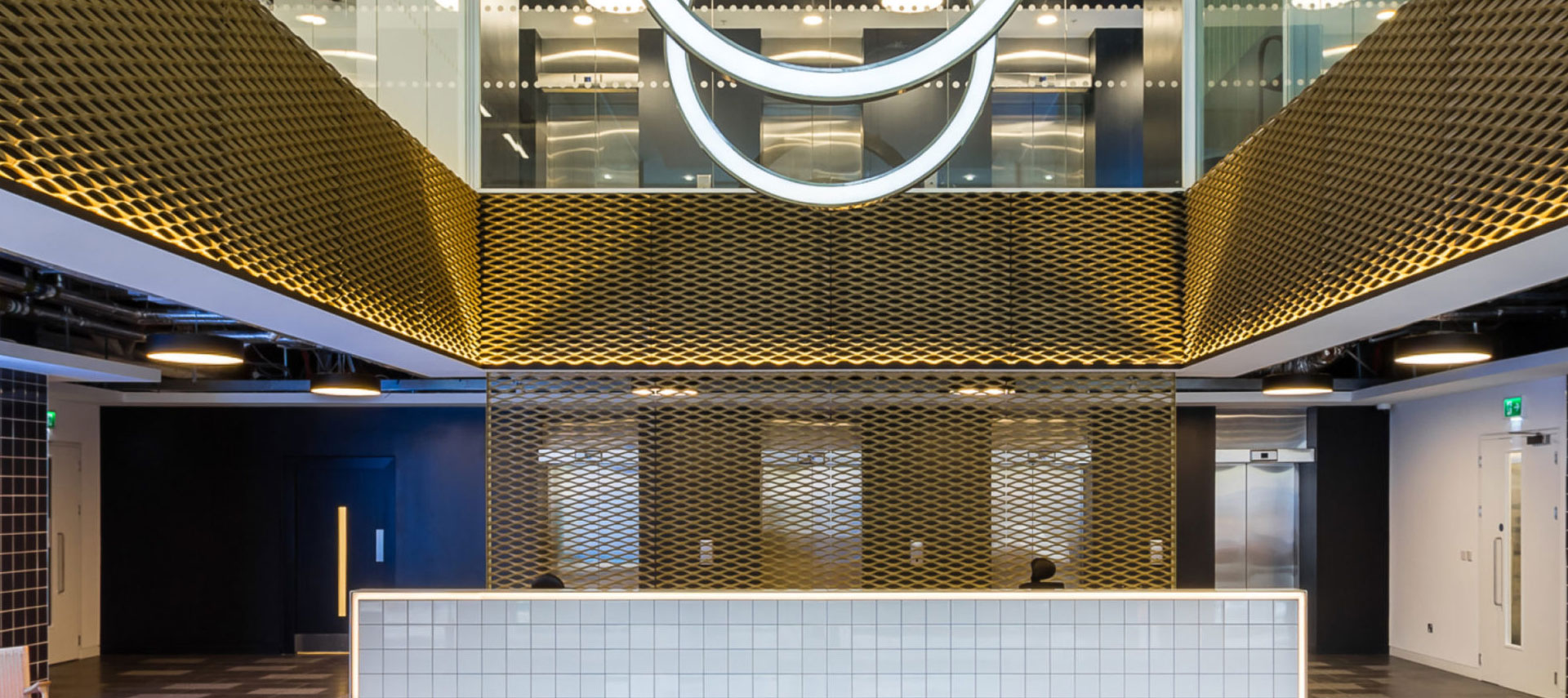 Interior featuring decorative metal mesh wall cladding and ceiling panels in a commercial space