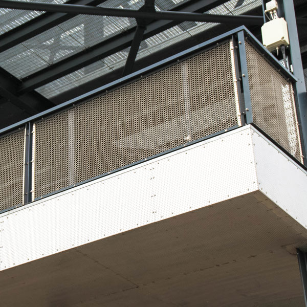 Corner balcony detail with metal mesh balustrade system in a modern building