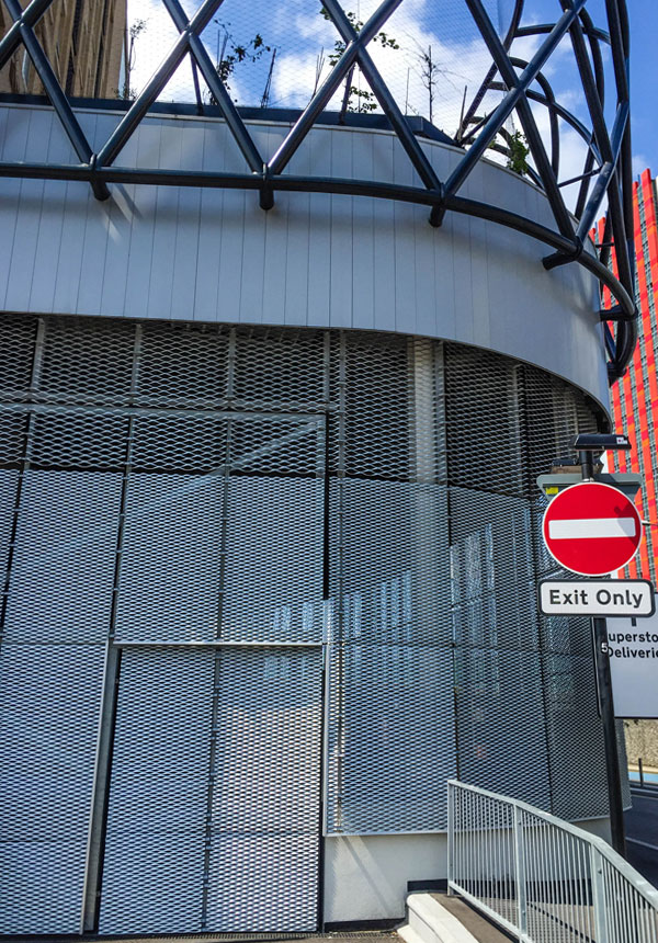 Street-level view of Hallsville Quarter with expanded metal mesh façade and signage