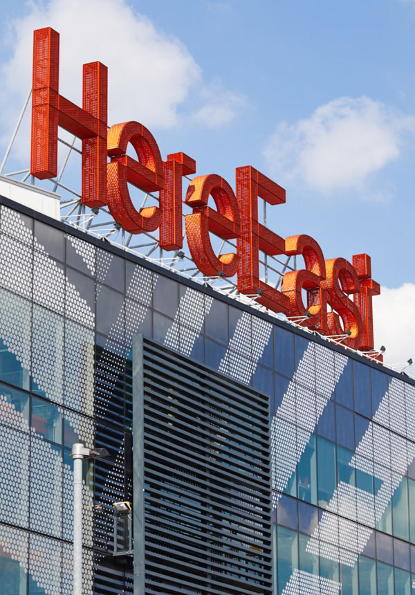 HereEastSign-Expanded-TALL1 Here East building exterior with expanded metal mesh façade and bold signage
