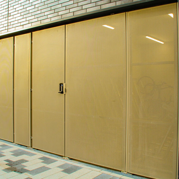 Perforated metal façade detail with integrated access doors.