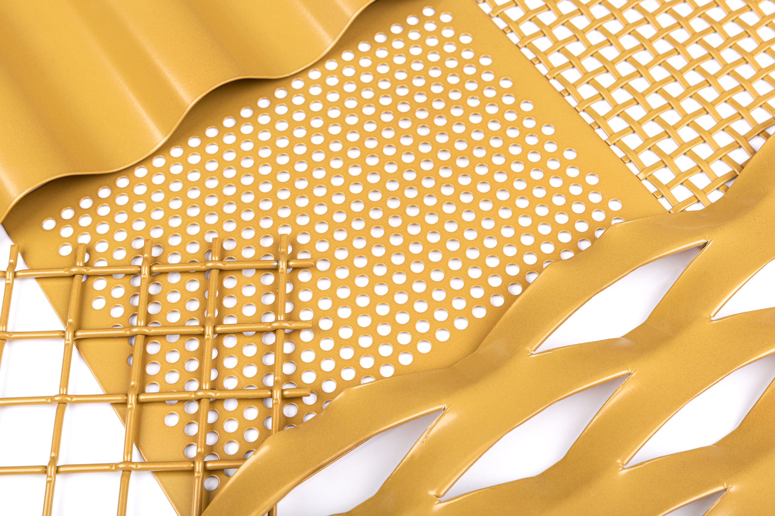 Close-up of perforated metal sheet samples in different finishes.