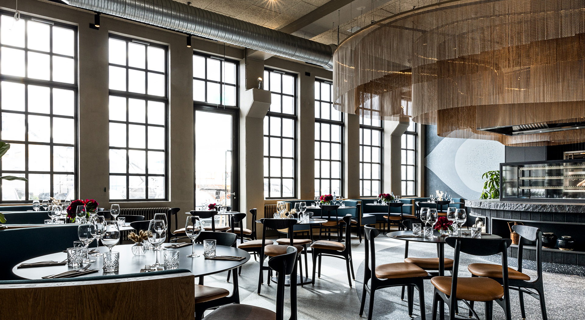 A large bar area with gold Kriskadecor ceiling drapery hanging above the bar with warm lights following the chains on the ceiling.