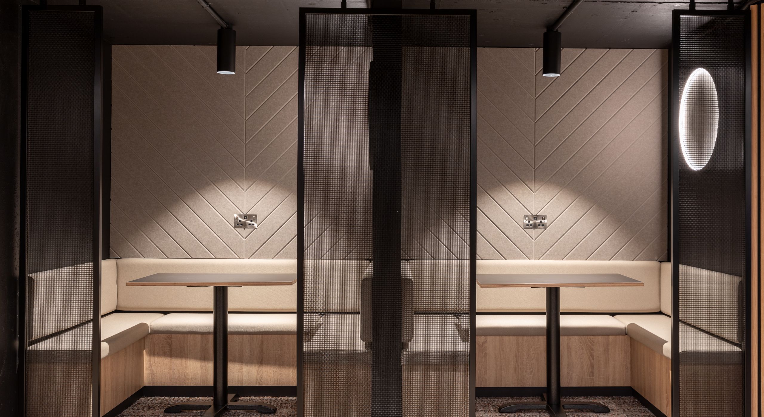 A cream work area with black mesh room dividers