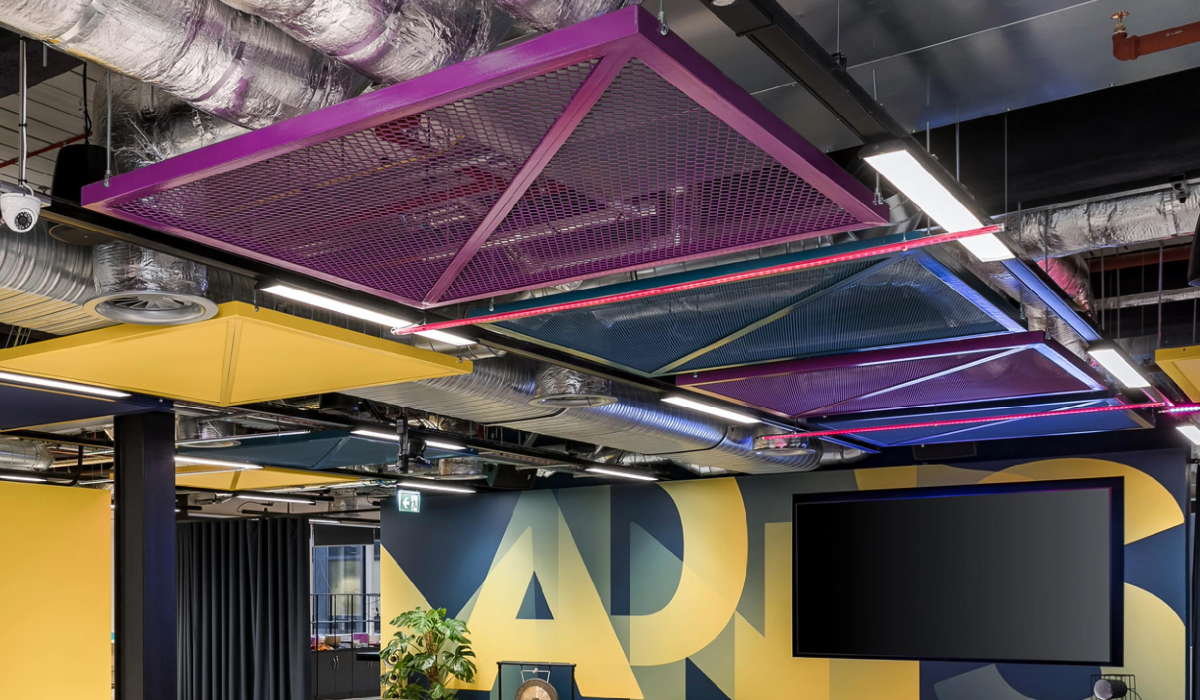 A colourful office with a bright purple ceiling grid