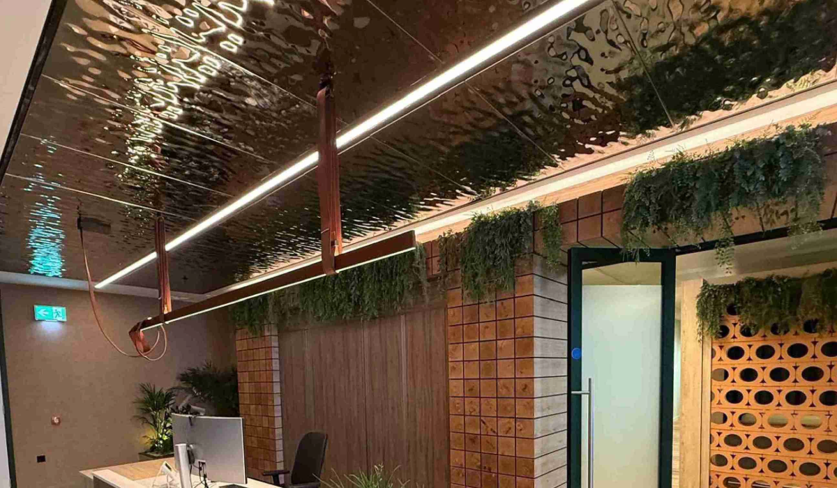 water ripple AC700W ceiling panels over a room with faux bricks and greenery