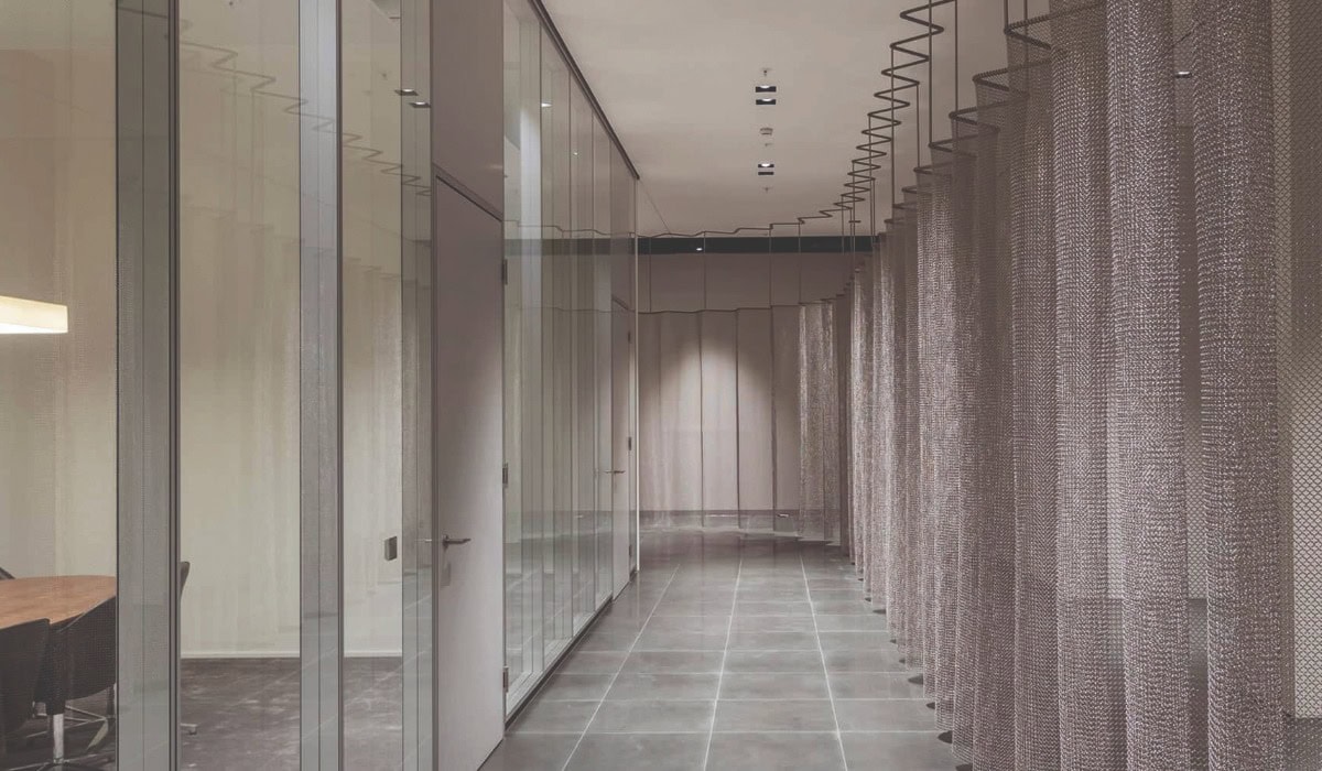 A silver alpha mesh curtain running along a corridor