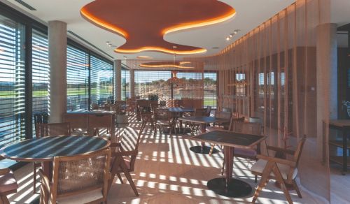 A gold alpha mesh curtain partitioning off a dining area