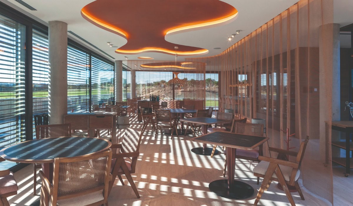 A gold alpha mesh curtain partitioning off a dining area