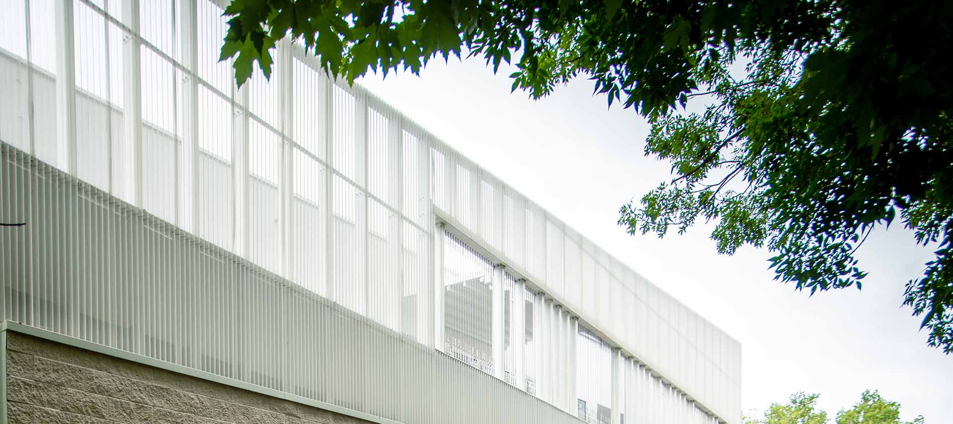 A close-up image of metal perforated wellTEC cladding in a white finish. 