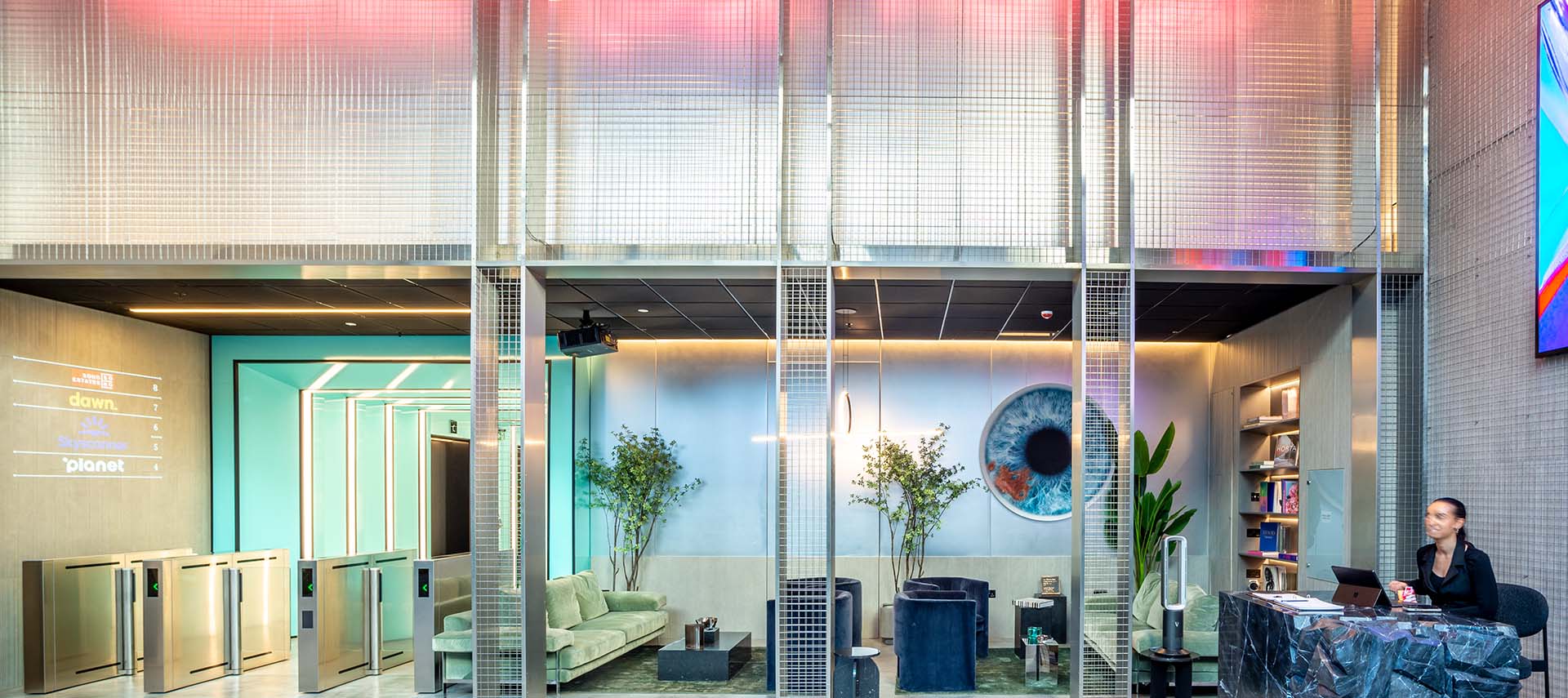 A reception room of a big office building. With blue LED lighting and decorative welded mesh in stainless steel. 
