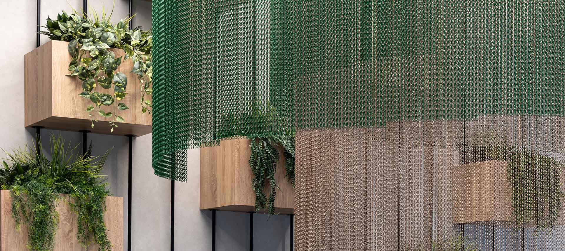 A reception room with Kriskadecor metal drapery hanging from it in green and sandy colours. 